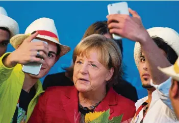  ?? FOTO: DPA ?? Selfie I: Nach ihrem Auftritt in Schwerin lässt sich die Kanzlerin mit syrischen Flüchtling­en ablichten.