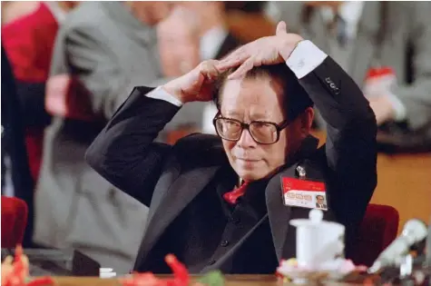  ?? ?? جيانغ زيمين يمشط شعره قبل بدء إحدى جلسات مؤتمر الحزب الحاكم في بكين. ⬛ أ.ف.ب