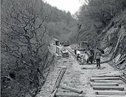  ??  ?? Laying the track out of Nant Gwernol station for the extension. The perilous drop off the edge along which the track originally ran can be seen on the left.