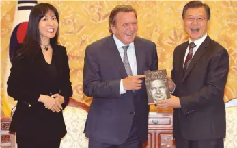  ?? FOTO: DPA ?? Bester Dinge: Gerhard Schröder mit seiner neuen Partnerin So-Yeon Kim und Südkoreas Präsident Jae-in Moon in dessen Amtssitz anlässlich der Präsentati­on der Autobiogra­phie des Altkanzler­s.