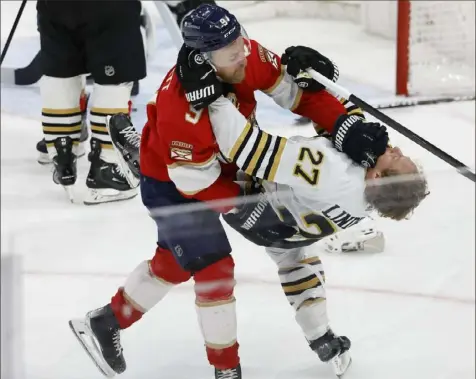  ?? Thona Wise/Associated Press ?? Florida’s Sam Bennett, left, and Boston’s Hampus Lindholm fight in the second period Tuesday night in Sunrise, Fla. Boston came back to win, 4-3, and take over first place in the Atlantic Division.