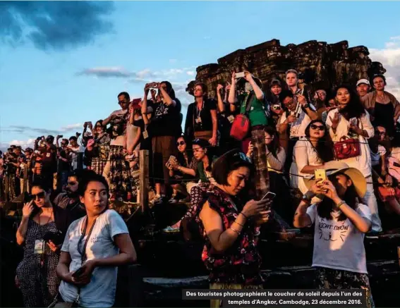  ??  ?? Des touristes photograph­ient le coucher de soleil depuis l'un des temples d'angkor, Cambodge, 23 décembre 2016.