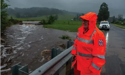  ?? Photograph: Phillip Biggs/EPA ?? SES volunteer Maxine Douce monitors the water level at a bridge in Railton, Tasmania, last week. More rain is forecast across Australia’s eastern states in the coming days.