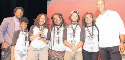  ?? PHOTO COURTESY OF GERLINDE PHOTOGRAPH­Y ?? The Miramar High School team, which won the Louder than a Bomb Florida finals, is flanked by Jason Taylor, right, and Darius Daughtry, director of poetry programs for the Omari Hardwick bluapple Poetry Network.