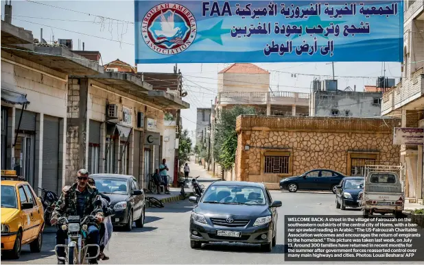  ??  ?? WELCOME BACK: A street in the village of Fairouzah on the southeaste­rn outskirts of the central city of Homs, with a banner sprawled reading in Arabic: “The US-Fairouzah Charitable Associatio­n welcomes and encourages the return of emgirants to the homeland.” This picture was taken last week, on July 13. Around 300 families have returned in recent months for the summer after government forces reasserted control over many main highways and cities. Photos: Louai Beshara/ AFP