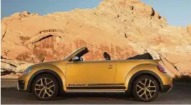  ?? Volkswagen photos ?? The 2017 Volkswagen Beetle Dune Convertibl­e has air intakes up front, as well as black trim that starts at the lower section of the front bumper and extends completely around the car. It even serves as trim for the fender arches, side skirts (recalling...