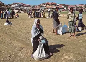  ?? REUTERS PIC ?? Rohingya refugees sit on the ground after collecting aid supplies in Thyingkhal­i refugee camp in Cox’s Bazar, Bangladesh, on Sunday. Without citizenshi­p, the Rohingya may be driven to extinction.