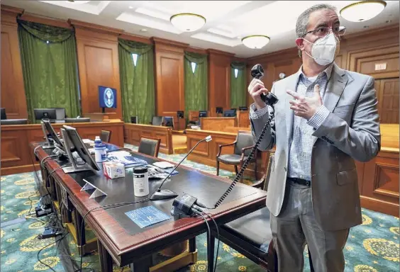  ?? Mary Altaffer / Associated Press ?? U.S. District Court District Executive Edward Friedland holds a phone device used to amplify attorneys’ voices in a courtroom at a Manhattan federal courthouse on March 12 in New York.