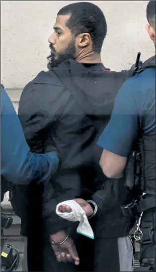  ??  ?? Suspect in handcuffs with tape round his right hand which appears to be bleeding