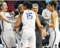  ?? THE ASSOCIATED PRESS ?? Connecticu­t players celebrate a victory over South Florida with coach Geno Auriemma, center, on Feb. 16 in Storrs, Conn.