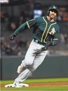  ?? Scott Strazzante / The Chronicle ?? A’s infielder Steve Lombardozz­i rounds third to score the go-ahead run in the 10th inning on a hit by Mark Canha.