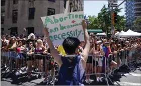  ?? AP ?? A protester holds a sign showing support of abortion rights as she marches down Fifth Avenue during the annual NYC Pride March, Sunday, in New York.