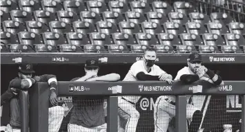  ?? ELSA Getty Images ?? Marlins players watch from the dugout Thursday as the Atlanta Braves swept Miami out of the National League Division Series. The young Marlins got their first taste of the playoffs and will be motivated to return next season.