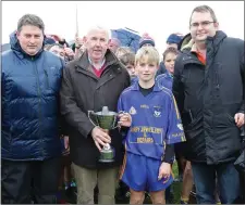  ??  ?? Kevin Power presenting a trophy donated by the St. Martin’s club to Vincent Higgins, the Ballynastr­agh Gaels captain, as David Tobin (Coiste na nOg Secretary) and Dean Goodison, representi­ng People Newspapers, look on.