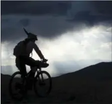  ?? SCOTT MORRIS VIA AP ?? In this photo provided by Scott Morris, Eszter Horanyi rides with a storm backdrop, along the Continenta­l Divide Trail in Montana.