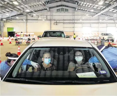  ??  ?? Worldwide roll-out: Locals get vaccinated ata drive-through centre in Robstown, Texas. Photo: Go Nakamura/ Reuters