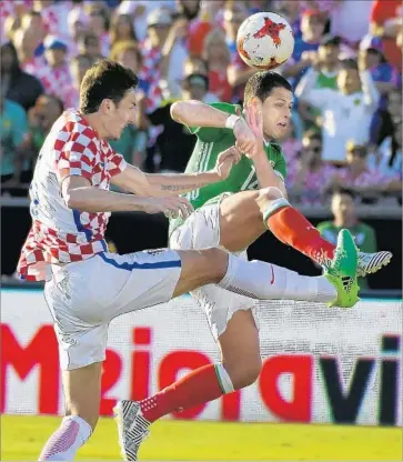  ?? Photograph­s by Mark J. Terrill Associated Press ?? A LOOSE ball sparks a battle between Croatia’s Zoran Nizic, left, and Mexico’s Javier Hernandez during the second half. Over the last 10 months, Mexico is 0-2 in California and unbeaten elsewhere.