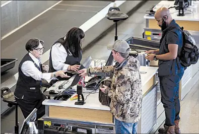  ?? Arkansas Democrat-Gazette/MITCHEL PE MASILUN ?? Travelers check in for a flight at Bill and Hillary Clinton National Airport/Adams field on Wednesday. The average price of a flight from Little Rock in 2017 was $445.35.