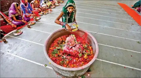  ?? A girl places offerings on a Shivling on the last day of Jaya Parvati Vrat festival at a temple in Ahmedabad on Thursday. REUTERS ??