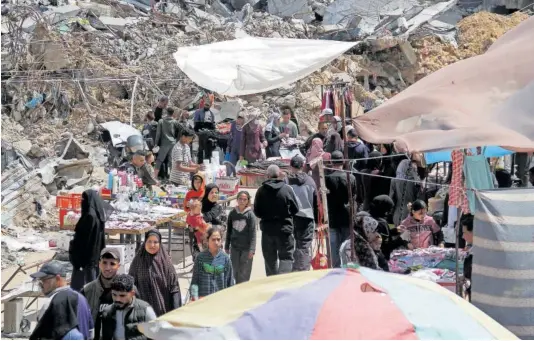  ?? MAHMOUD ISSA (REUTERS) ?? Ciudadanos palestinos hacían compras ayer en el norte de Gaza para festejar el final del Ramadán.