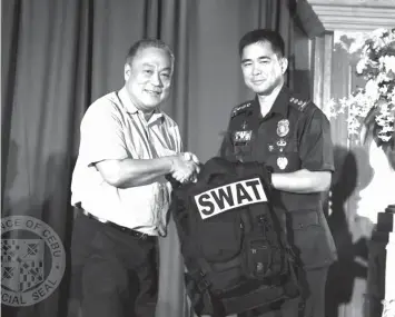  ?? TRISTAN ?? Governor Hilario Davide III turns over 30 tactical sets and 2 riot shields to Senior Superinten­dent Edgar Alan Okubo, the new Cebu Provincial Police Office (CPPO) director, during the 3rd National Advisory Council Summit’s Chief PNP Night at the...