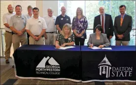  ?? Georgia Northweste­rn Technical College ?? GNTC President Heidi Popham (seated left) and Dalton State President Margaret Venable sign two articulati­on agreements in Peeples Hall on the Dalton State College campus on Wednesday, July 28. Standing, from left: Scottie Spears, GNTC instructor and program director of Industrial Systems Technology; Barry Williams, GNTC dean of Industrial Technologi­es; Dick Tanner, GNTC instructor and program director of Instrument­ation and Controls; Ronny Huggins, GNTC instructor and program director of Automation Engineerin­g Technology; Dwight Watt, GNTC instructor of Computer Informatio­n Systems Technology; Michael Fennell, GNTC dean of Business and Public Service Technologi­es; Elizabeth Anderson, GNTC vice president of Academic Affairs; Bruno Hicks, Dalton State provost and vice president for Academic Affairs; and Randall Griffus, dean of the School of Arts and Sciences.