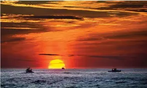  ?? AP Photo/robert F. Bukaty ?? Lobster fishermen are already at work as the sun rises Thursday over the Atlantic Ocean off the coast of Kennebunkp­ort, Maine.