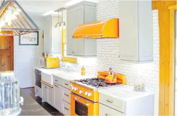  ?? BRAND VIVA ?? Bright orange Big Chill appliances — the microwave, stove and range hood — provide colourful contrast to the neutral cabinetry and inject personalit­y into the space.