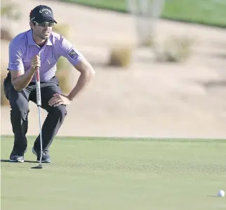  ?? MATT SULLIVAN/GETTY IMAGES ?? Adam Hadwin eyes a birdie putt during the second round of the Waste Management Phoenix Open Friday in Scottsdale, Ariz. Hadwin shot a 65 and is tied for eighth heading into the weekend.