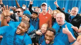  ?? STEPHEN M. DOWELL/AP ?? Former NFL quarterbac­k Peyton Manning, wearing a red shirt, is surrounded by cheering athletes in an airplane hangar during“Special Olympics Airlift”on Saturday at Orlando Executive Airport in Orlando.