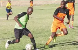  ??  ?? Bulawayo Chiefs’ striker Farai Matare (left) tries to make his way past Makomo defender Kainos Masocha at Hartsfield Ground yesterday. Bulawayo Chiefs won 2-0 to secure a place into the Premier Soccer League next season.