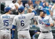  ?? Elaine Thompson Associated Press ?? JUSTIN TURNER is greeted at the plate by Dodgers teammates after hitting a three-run homer.