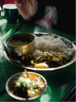  ?? ?? [below] A welcome meal of Dal bhat with local river fish curry