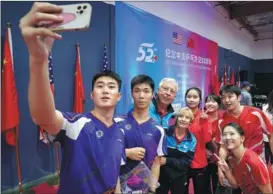  ?? LIU GUAN GUAN / CHINA NEWS SERVICE ?? Players of Peking University’s table tennis team pose for a group photo on Dec 15 , in San Francisco, California, in the US, with Dell and Connie Sweeris, who were part of the team from the United States that visited China in 1971.