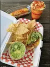  ?? THE AJC WENDELL BROCK FOR ?? Among the offerings at Chi Chi Vegan Taco Shop are chips and guacamole with an al pastor taco in a crispy corn tortilla; Mexican corn on the cob; and a mango drink.