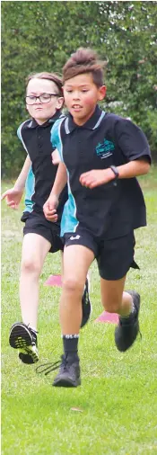  ?? ?? Finding a burst of speed as they approach the cheer zone, Hugo Pankhurst leads Connor Perrins in the cross country race.