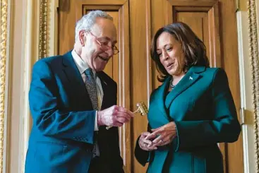  ?? STEPHANIE SCARBROUGH/AP ?? Senate milestone: Senate Majority Leader Chuck Schumer, D-N.Y., presents Vice President Kamala Harris with a golden gavel Tuesday after she cast her 32nd tie-breaking vote in the Senate, the most ever by a vice president. She later cast a 33rd vote. The previous champion was John C. Calhoun, who cast 31 tie-breaking votes from 1825 to 1832.