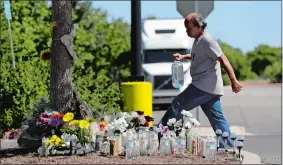  ?? ERIC GAY/AP PHOTO ?? A man delivers a large bottle of water to a makeshift memorial Wednesday in the parking lot of a Walmart store near the site where authoritie­s Sunday discovered a tractor-trailer packed with immigrants outside a Walmart in San Antonio. Several people...