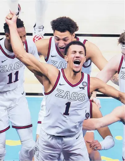  ?? ANDY LYONS/GETTY ?? Jalen Suggs celebrates with teammates after his jaw-dropping shot that lifted Gonzaga into Monday’s championsh­ip game.