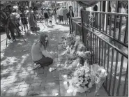  ?? AP/JOHN MINCHILLO ?? A mourner kneels at a makeshift memorial Monday outside the Hole in the Wall bar in Dayton, Ohio, where nine people were killed Sunday morning in a mass shooting.