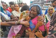  ?? Ajit Solanki / Associated Press ?? Indian flood victims break down after meeting at a camp for the displaced in Gujarat state.