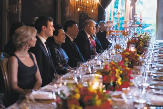  ?? Jim Watson / AFP / Getty Images ?? President Trump (center) hosted Chinese President Xi Jinping (to his left) in April at Mar-a-Lago in Florida and served Caesar salad, sauteed sole and steak.