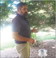  ?? Amanda Cuda / Hearst Connecticu­t Media ?? John Shepard of the Connecticu­t Agricultur­al Experiment Station in New Haven demonstrat­es how to hang a mosquito trap at the station on June 3.