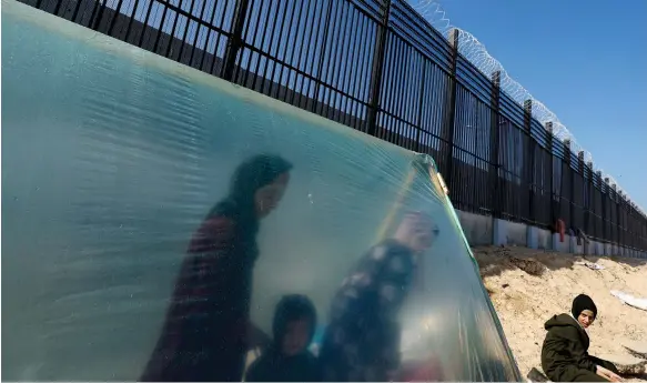  ?? Reuters ?? Displaced Palestinia­ns use plastic sheets to build a shelter in a camp in Rafah in the southern Gaza Strip, close to the border with Egypt