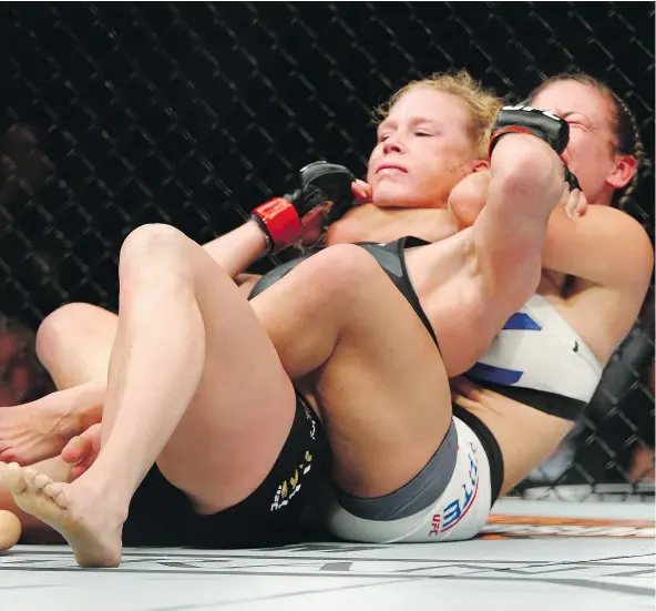  ?? — THE ASSOCIATED PRESS FILES ?? Miesha Tate chokes Holly Holm in their UFC 196 bantamweig­ht mixed martial arts match a year ago in Las Vegas.