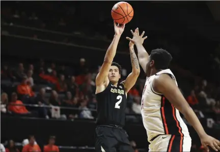  ?? AMANDA LOMAN — THE ASSOCIATED PRESS ?? Colorado guard KJ Simpson, left, shoots over Oregon State center KC Ibekwe, right, during the second half on Saturday in Corvallis, Ore.
