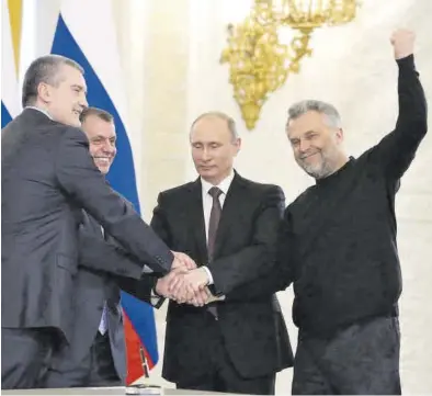  ?? EKATERINA SHTUKINA / EFE ?? El presidente Putin une sus manos con las de los máximos dirigentes de Crimea para sellar su unión, hace 10 años.