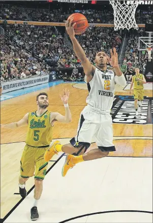  ?? AP PHOTO ?? West Virginia guard Jevon Carter (2) drives to the basket against Notre Dame forward guard Matt Farrell (5) during a second-round men’s college basketball game in the NCAA Tournament Saturday in Buffalo, N.Y.