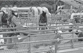  ?? HIRO KOMAE/AP ?? Workers put constructi­on materials away before their lunch break at the Fukushima Daiichi nuclear plant in Futaba, Japan, on Friday. The Internatio­nal Atomic Energy Agency says Japan’s wastewater-release plan would cause negligible radioactiv­ity in the sea.