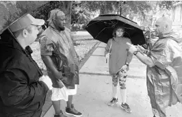  ?? KATE SANTICH/STAFF ?? Outreach workers, left to right, Brian Postlewait, Alvin Colbert, Nyssa Olness and Dewey Wooden gather as they search for homeless residents who still hadn’t sought shelter.